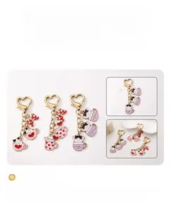Detail of heart-shaped alloy keychain with enamel cat, red heart and polka dot bow