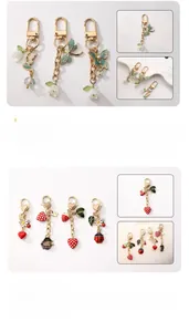 Detail of ladybug and strawberry charms with enamel finish and gold plating on keychain