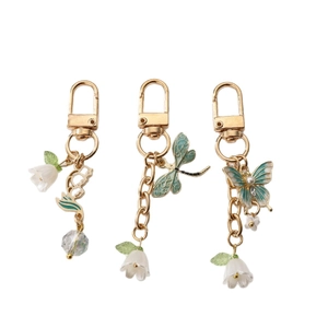 Drei Maiglöckchen-Schlüsselanhänger mit Emaille-Libelle und Schmetterling in Gold
