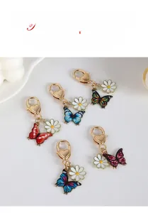Detail view of colorful butterfly metal keychains with heart clasp and daisy flower charms
