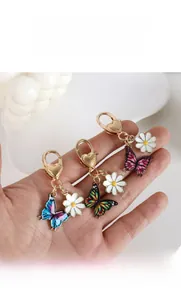 Detail of colorful butterfly keychains with white daisies and gold heart lobster clasps