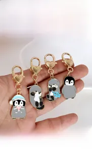 Simpatici portachiavi in metallo con pinguino e lontra e chiusure dorate a forma di cuore