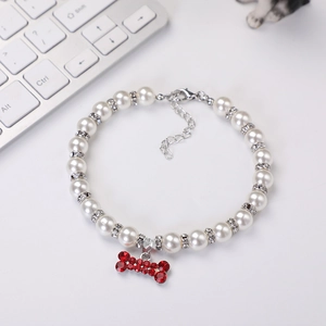 Detail of pearl pet necklace with sparkling red rhinestone bone pendant and crystal spacers
