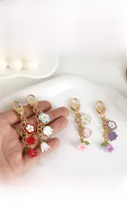 Détail du fermoir mousqueton en cœur et des pendentifs fleurs de muguet en émail