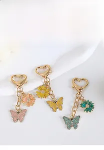 Detail von bunten Emaille-Schmetterling-Schlüsselanhängern mit goldenem Herzverschluss