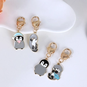 Set portachiavi smaltati con pinguino e lontra e moschettoni dorati a cuore