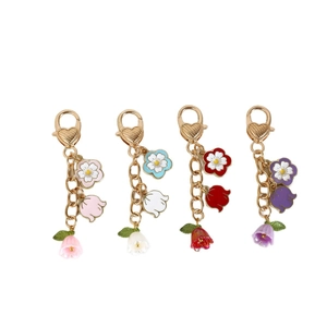 Lot de quatre porte-clés muguet avec fermoirs mousquetons dorés et pétales en résine