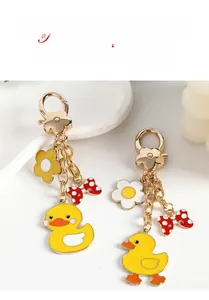 Exquisite metal duck keychain featuring polka dot bow and floral charms on a tray