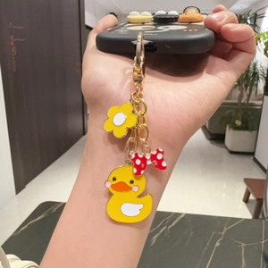 Cute yellow duck keychain with flower and bow pendant on golden metal clasp