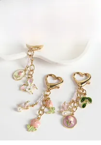 Vue détaillée du pendentif tulipe émaillée et cœur perlé sur le porte-clés doré
