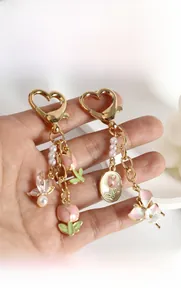 Vue détaillée du porte-clés en métal tulipe rose et papillon avec perles blanches