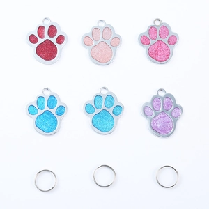 Glitter paw shape pet ID tags in various colors with metal rings on white background