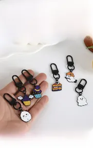 Detail of Halloween enamel keychains featuring cute ghosts and spooky cupcake charms