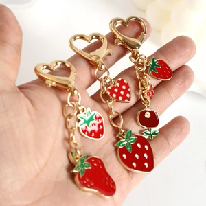 Three-piece strawberry keychain set with heart-shaped gold hooks and enamel fruit charms