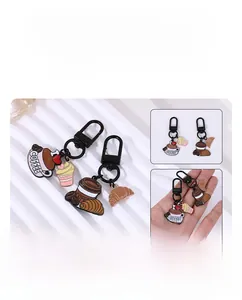 Detail of coffee themed enamel metal keychains featuring croissant and cupcake charms