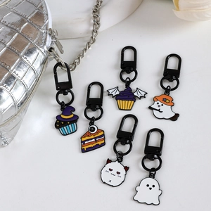 Halloween enamel keychains set featuring ghost and pumpkin cake charms on white background
