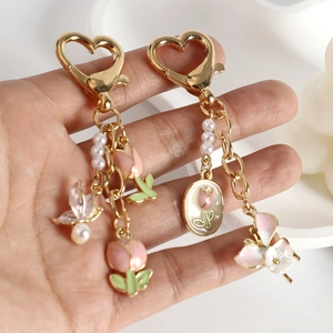 Porte-clés cœur doré avec pendentif tulipe rose et breloques papillon en perles