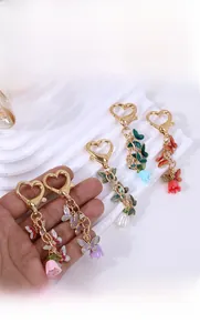 Detailed close-up of butterfly and lily flower charms with enamel finish on heart keychain