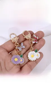 Gros plan d'un porte-clés marguerite avec fermoir coeur et pendentif papillon