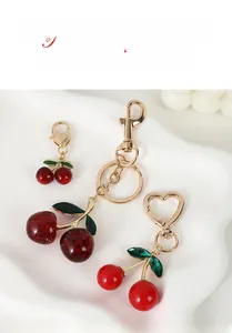 Gros plan du porte-clés cerise avec fermoir cœur doré et perles rouges brillantes