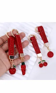 Detailed macro view of cherry and strawberry keychains with red and green rhinestones