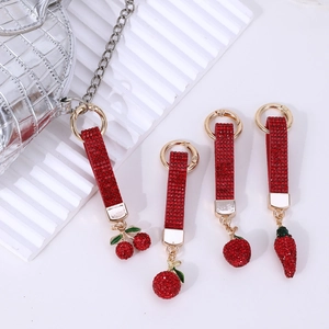 Red rhinestone cherry and apple fruit keychains on silver luxury crocodile leather bag