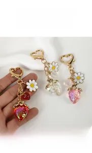 Dettaglio macro di ciondoli a fragola traslucidi con glitter e chiusura in metallo a cuore