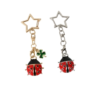 Lucky ladybug keychains in gold and silver metal with star-shaped rings and enamel detail