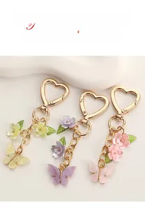Détail de porte-clés papillon et fleur colorés avec fermoirs en forme de cœur