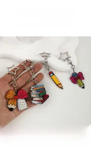Macro shot of colorful acrylic bow pencil and book charms with star-shaped keychains
