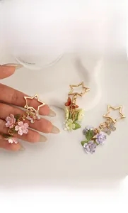 Detailed close-up of colorful enamel flower and butterfly charms on a star-shaped keychain