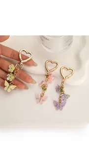 Détail de porte-clés papillon et fleurs colorés avec crochets dorés en forme de cœur