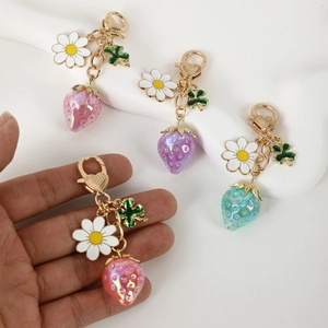 Translucent strawberry flower keychain with gold heart lobster clasp and daisy charms