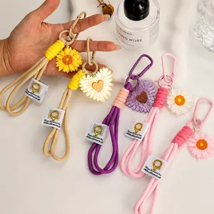 Close-up of colorful hand-woven phone lanyards with daisy charms and metal carabiner clips