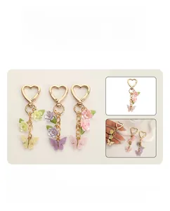 Dettaglio di portachiavi colorati a farfalla e fiore con ganci in metallo a cuore