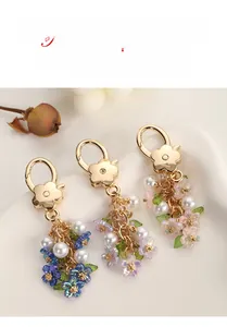 Detail of colorful pearl flower keychains with gold spring clasps in pink blue and purple