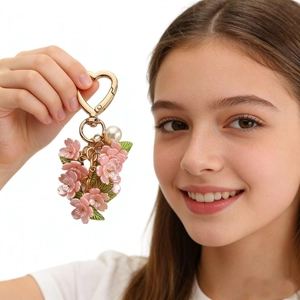 Elegant pink cherry blossom keychain with gold heart clasp and pearl detail on hand