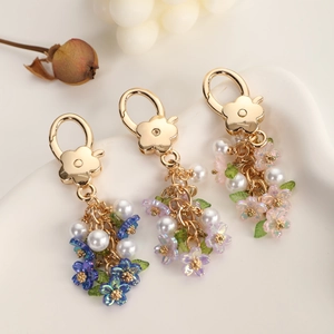 Colorful pearl flower keychains in blue, purple, and pink with golden flower clasps