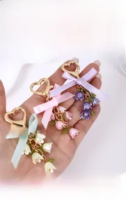 Detail van lelietje-van-dalen sleutelhangers met hartgespen, linten en parels in drie kleuren