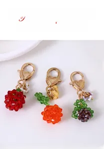 Detailed close-up of handmade fruit beads charms with golden heart-shaped lobster clasps