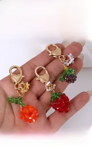 Detailed view of colorful berry-shaped beads on a golden heart-textured keychain