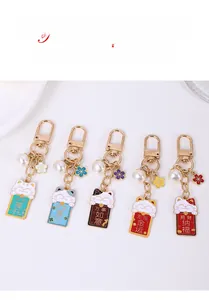 Close-up of cute Maneki Neko cat keychains with enamel glaze and gold lobster clasp details