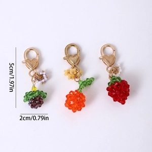 Handmade beaded fruit keychain with golden heart clasp in purple, orange, and red colors