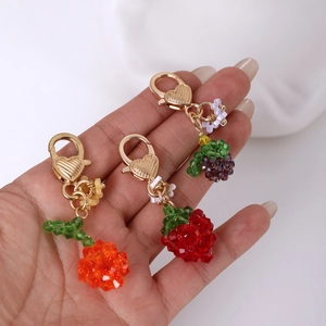 Handmade beaded strawberry, grape, and flower keychains with gold heart-embossed lobster clasps