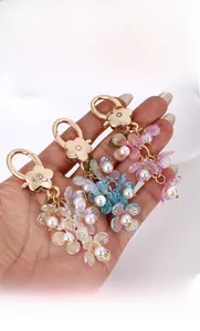 Detailed close-up of acrylic flower keychains with pearls in pink, purple, and blue hues