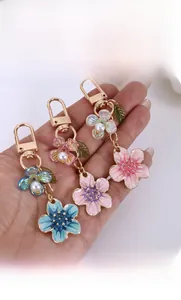 Detail view of colorful enamel cherry blossom keychains with pearls and gold clasps