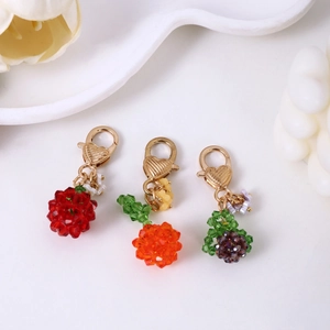 Three crystal fruit bead keychains including strawberry orange and grape with heart clasps