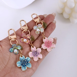 Handheld set of cherry blossom keychains with enamel flowers and white pearls