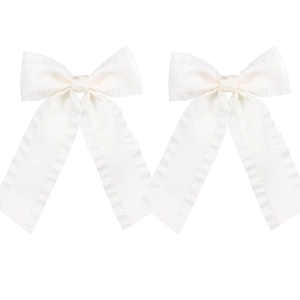 Close-up of a pair of white satin bow hair clips with ruffled edges and elegant drape