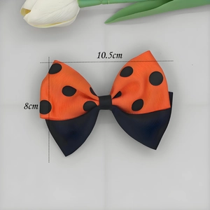 Détail d'un nœud en ruban gros-grain de 10,5 cm avec pois orange et noirs élégants